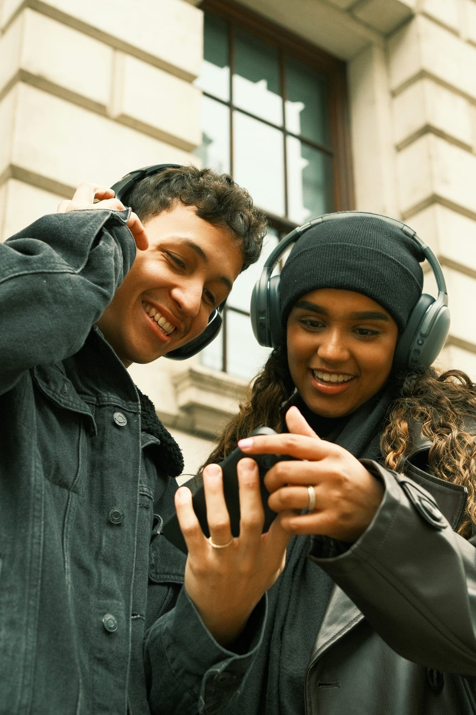 Samenwerking rond audio: twee mensen luisteren naar content op een telefoon