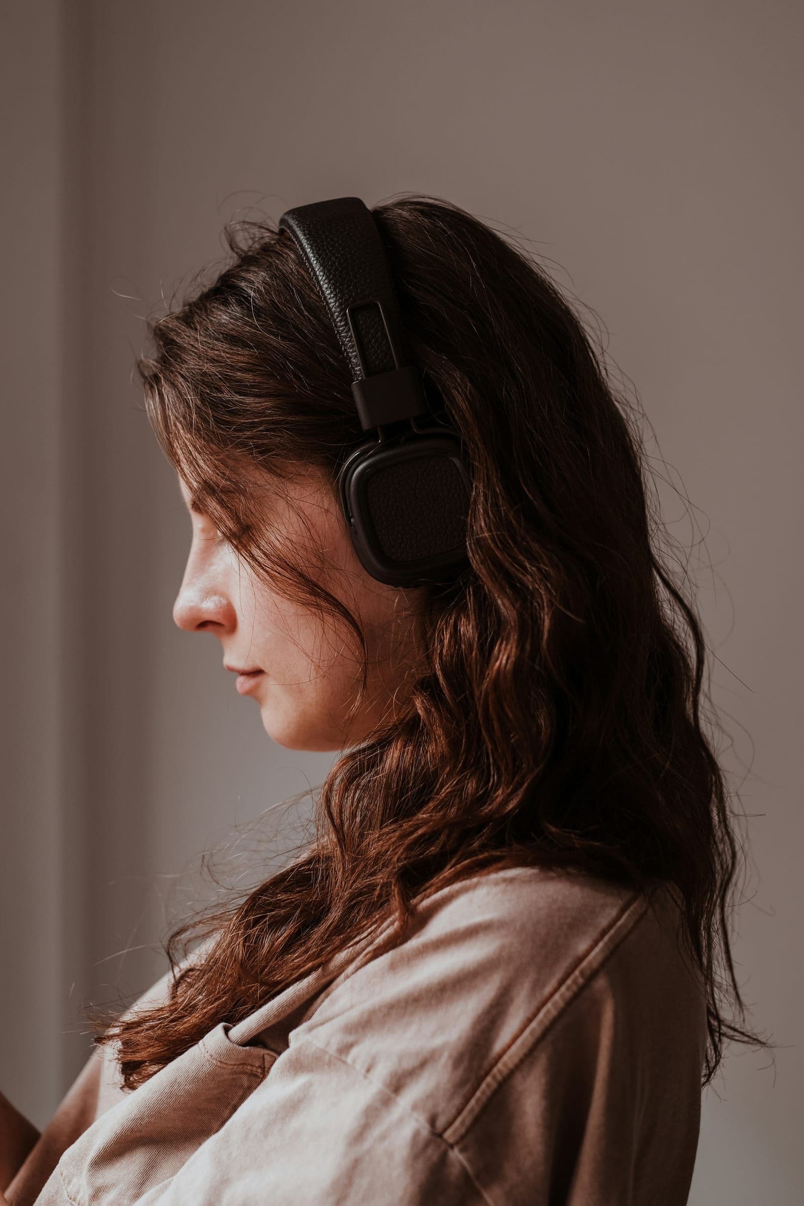 Vrouw luistert geconcentreerd naar een podcast met oortjes
