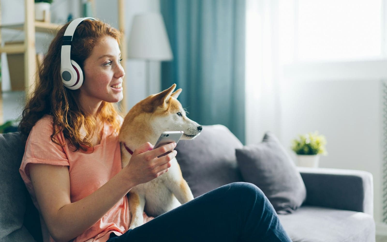 Luisteraar met koptelefoon volgt een podcast op de bank